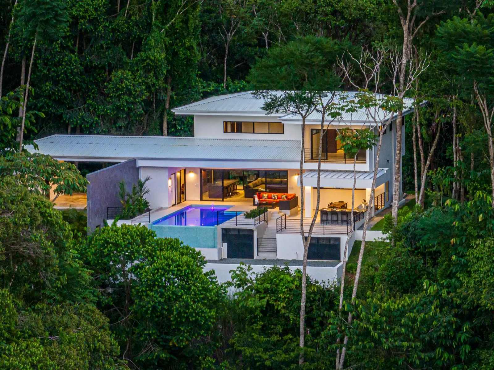 The residence glowing within the jungle canopy at dusk